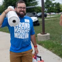 Volunteer carrying rolled up rug